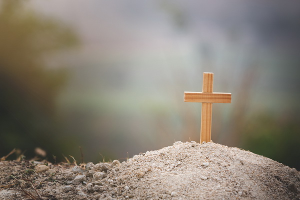 a wooden cross on a hill